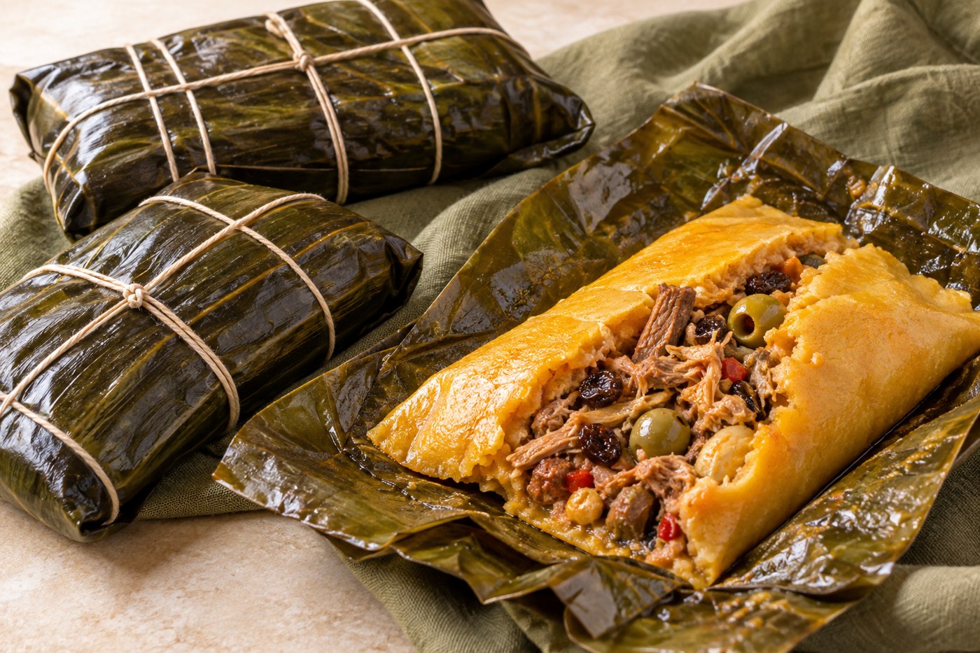 Imagen ilustrativa de una hallaca venezolana abierta sobre una hoja de plátano